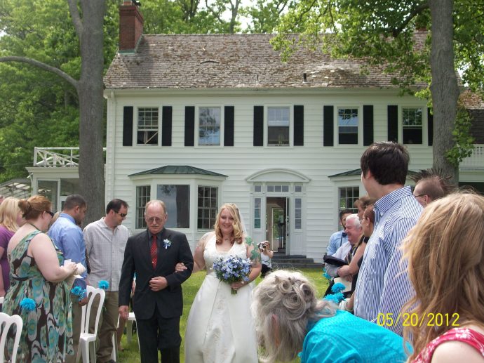 The father of the bride walks her down the aisle at Bayfields Bed and Breakfast