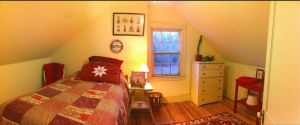 Rapunzel, the 3rd floor guest room at Bayfields Bed and Breakfast, showing off it's red and white theme, has a warm glow at dusk.